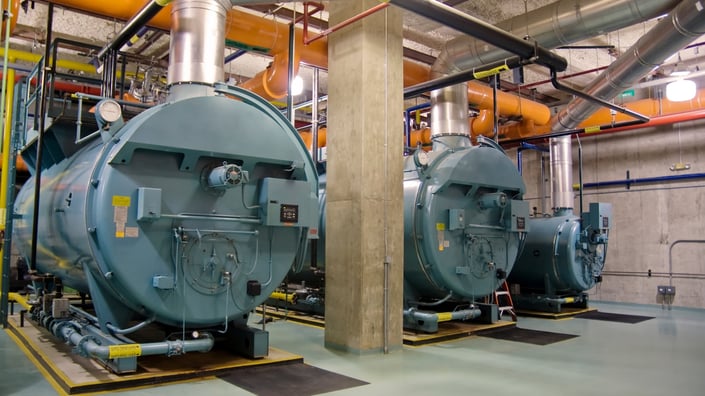 Technician performing preventive boiler maintenance in August before winter season.  (Blog Image)